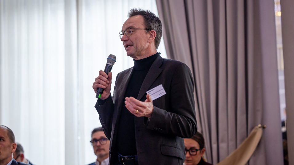 Teilnehmer spricht mit Mikrofon vor Publikum im Plenum beim SZ-Versicherungstag 2026